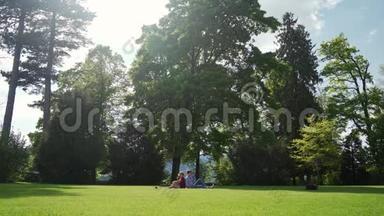 春天野餐时，一家人坐在草地上，时坐在草地上